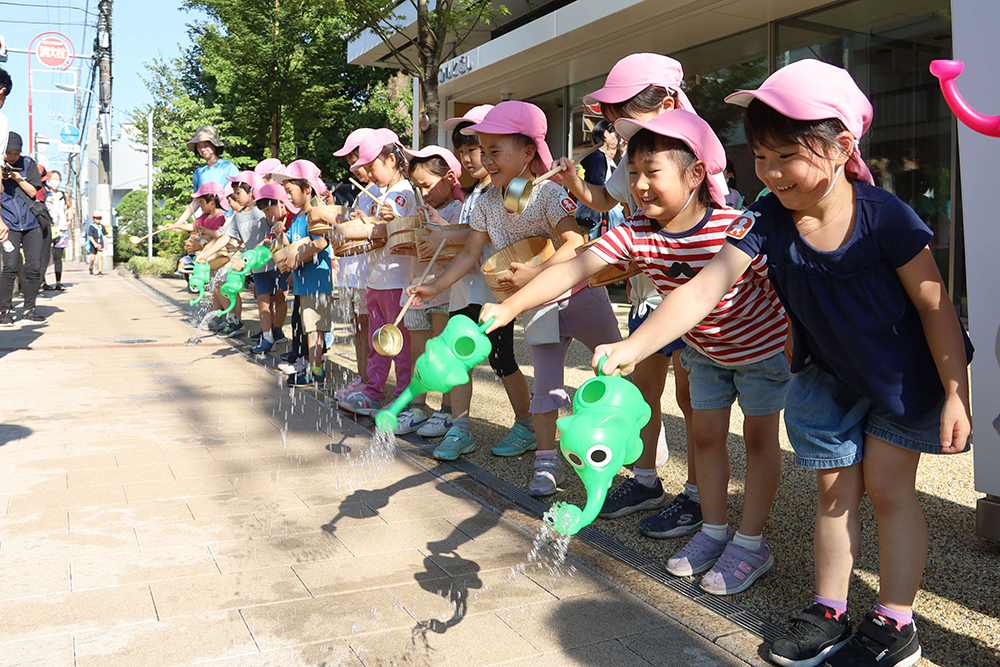 笑顔で水をまく子どもたち